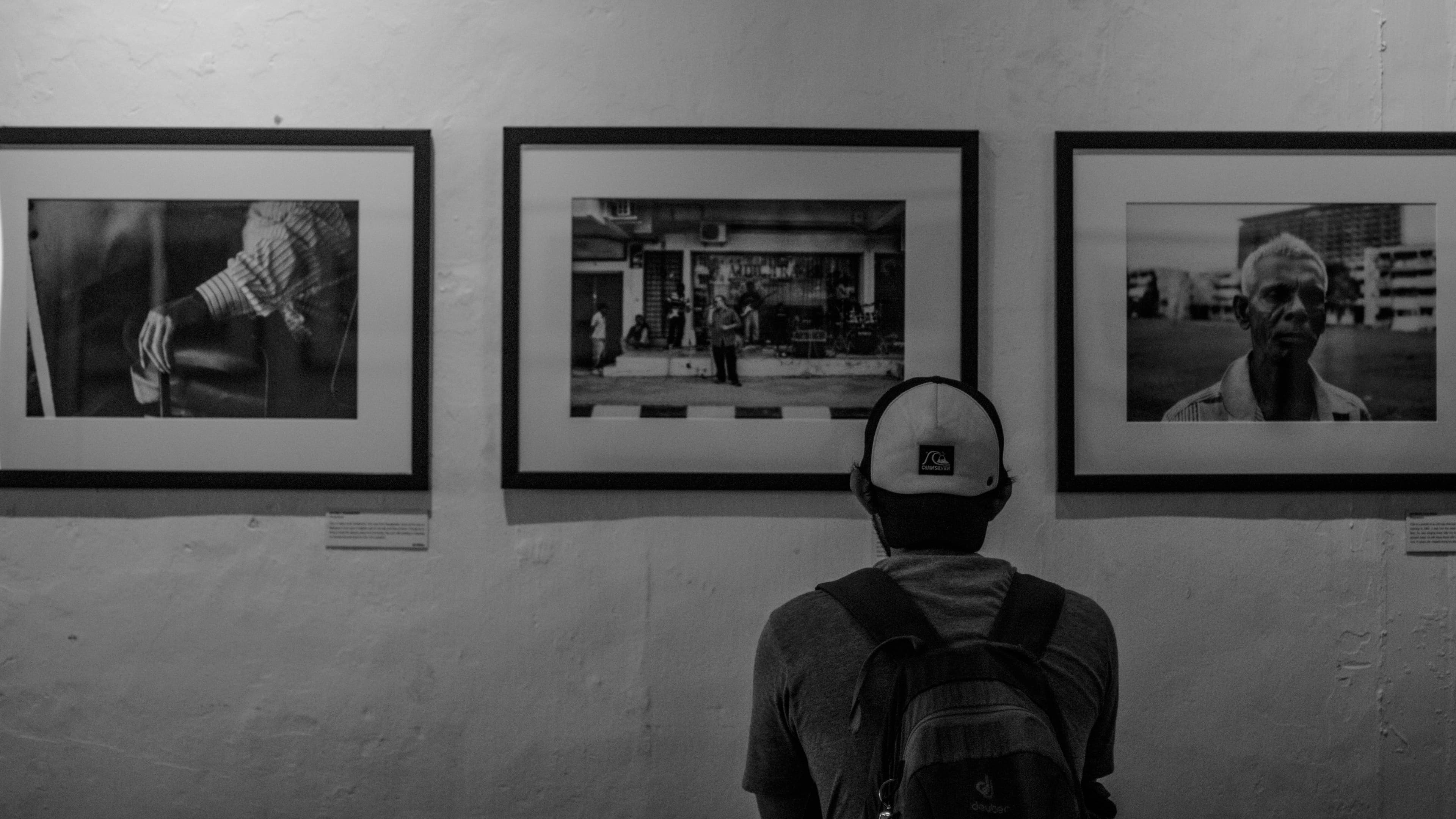 Person viewing framed photographs